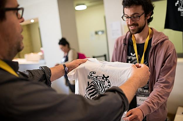 Un asistente observa una de las camisetas del 'merchandising' del festival.
