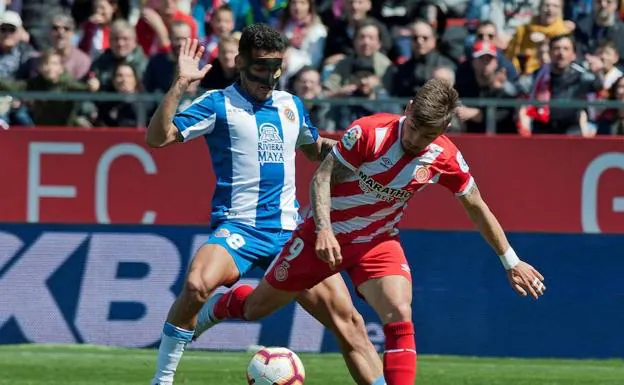 El jugador del Espanyol Roberto Rosales disputa un balón con el jugador del Girona Cristian Portugués 'Portu'.