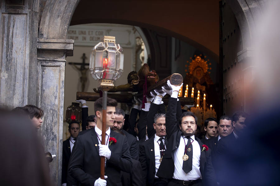 La imagen de Los Agustinos ha salido a la calle sobre las manos de los costaleros y rodeado de decenas de personas que le siguen con una vela encendida