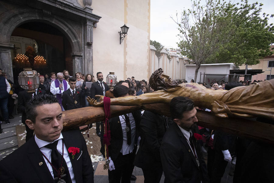 La imagen de Los Agustinos ha salido a la calle sobre las manos de los costaleros y rodeado de decenas de personas que le siguen con una vela encendida