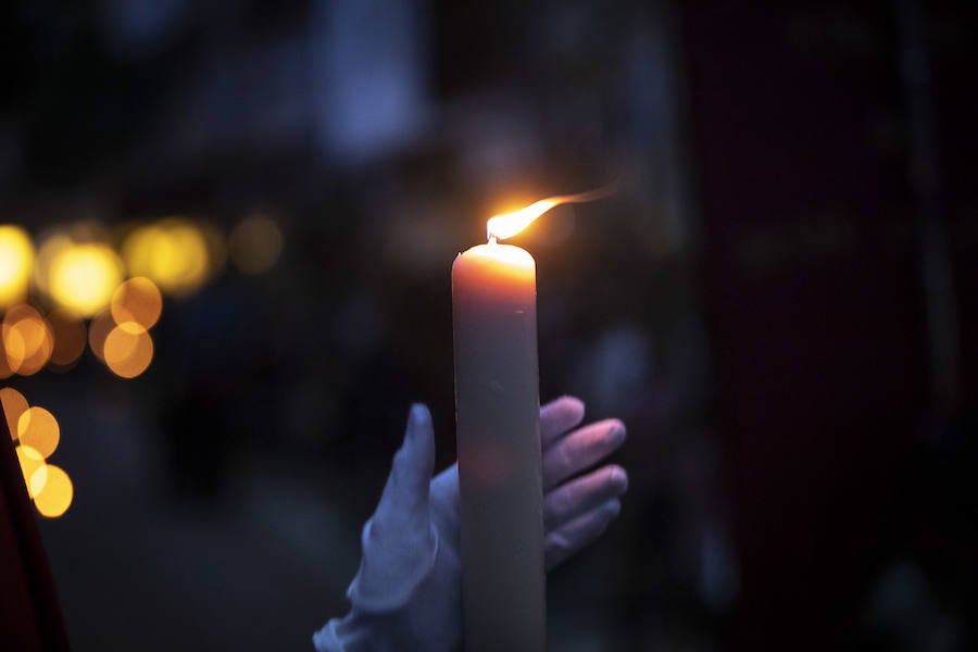 La imagen de Los Agustinos ha salido a la calle sobre las manos de los costaleros y rodeado de decenas de personas que le siguen con una vela encendida