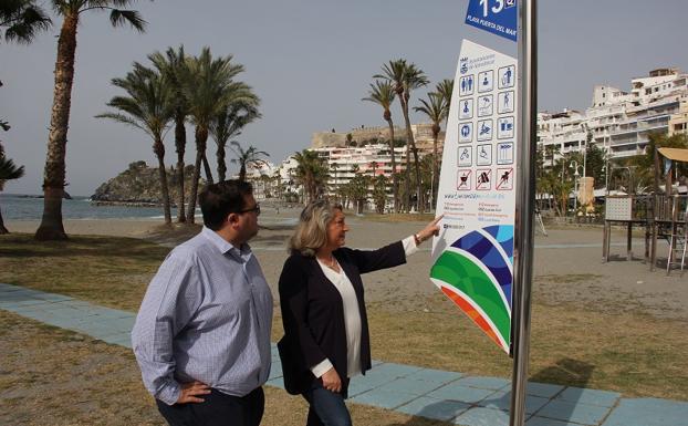 Rafael Caballero y Trinidad Herrera observan una de las banderolas de las playas. 