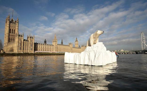 Escultura de un oso polar y su cría varados en un iceberg discurre por el río Támesis. 