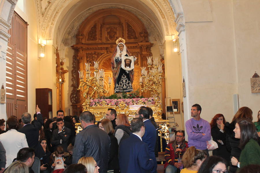 Largas colas pese al mal tiempo y lluvia de claveles para El Abuelo, con un ojo en el cielo a horas de su salida en procesión