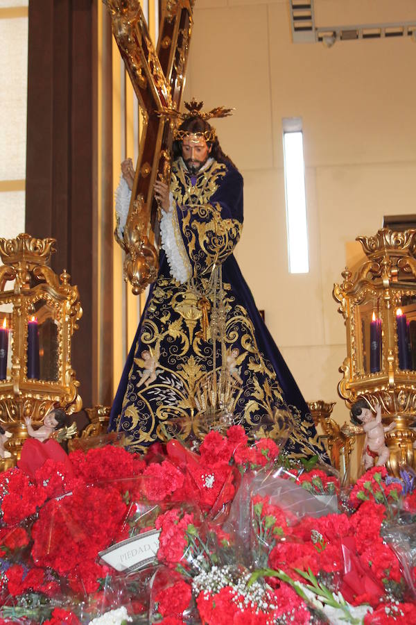 Largas colas pese al mal tiempo y lluvia de claveles para El Abuelo, con un ojo en el cielo a horas de su salida en procesión