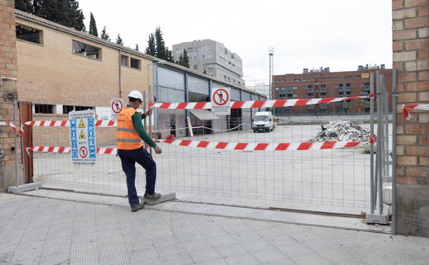 Un operario coloca la valla que restinge el acceso al solar