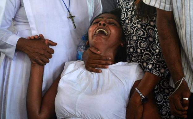 Una mujer llora durante uno de los funerales. 