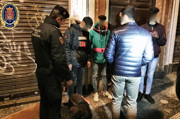 Un agente de la Policía Local identifica a unos jóvenes en la calle Elvira