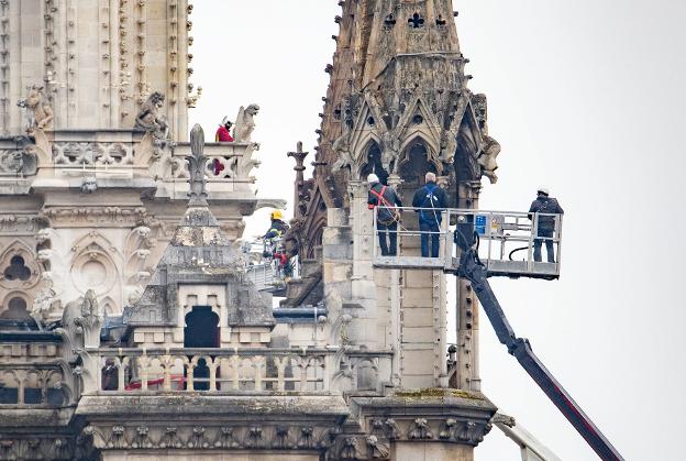 Bomberos y técnicos examinan los desperfectos causados por el fuego en Notre Dame.