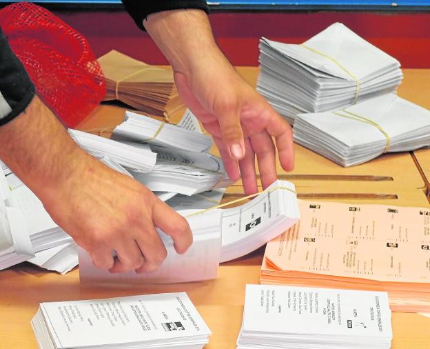 Una persona prepara las papeletas con los candidatos al Congreso y al Senado en un colegio electoral de Almería. 