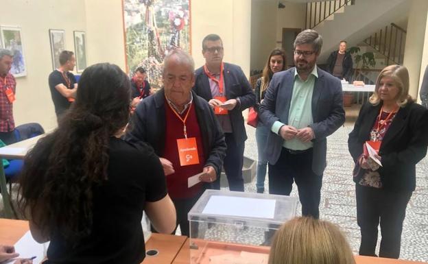 Fran Hervías (camisa verde) junto a sus padres frente a la mesa electoral.