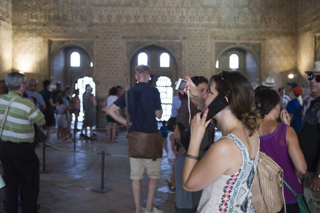 Una turista escucha las explicaciones de una audioguía durante su visita al monumento.