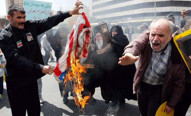 Manifestantes iraníes queman banderas estadounidenses durante una protesta el pasado viernes en Teherán. 