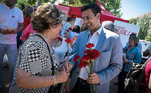 Cuenca entrega un clavel a una vecina.