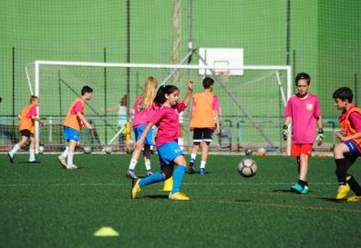 Imagen secundaria 1 - La coordinadora Amalia Fernández, muy atenta al entrenamiento. Paula brega por un balón dividido durante el entrenamiento alevín. Cayetana, entrena a tope con sus compañeros.