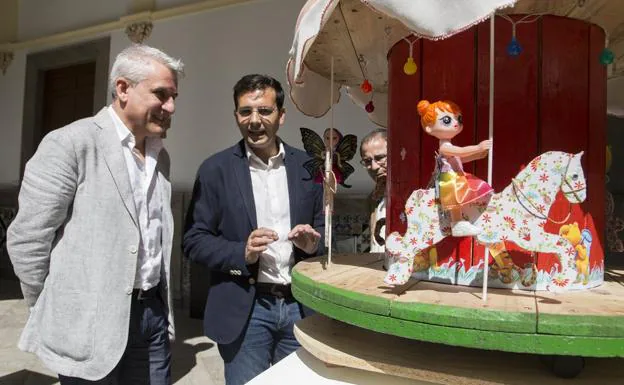 Blas Calero y Francisco Cuenca, junto a un carrusel realizado con palés de madera.