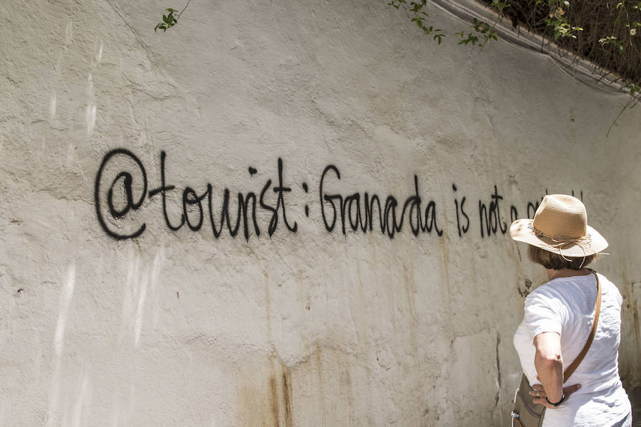 Los grafitis animan a los visitantes a marcharse de la ciudad y les acusan de desvirtuar la esencia del barrio granadino