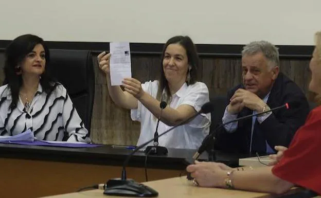 Una de las componentes de la Junta Electoral muestra la papeleta del PSOE, la ganadora del sorteo para dirimir el quinto concejal en Güevéjar.