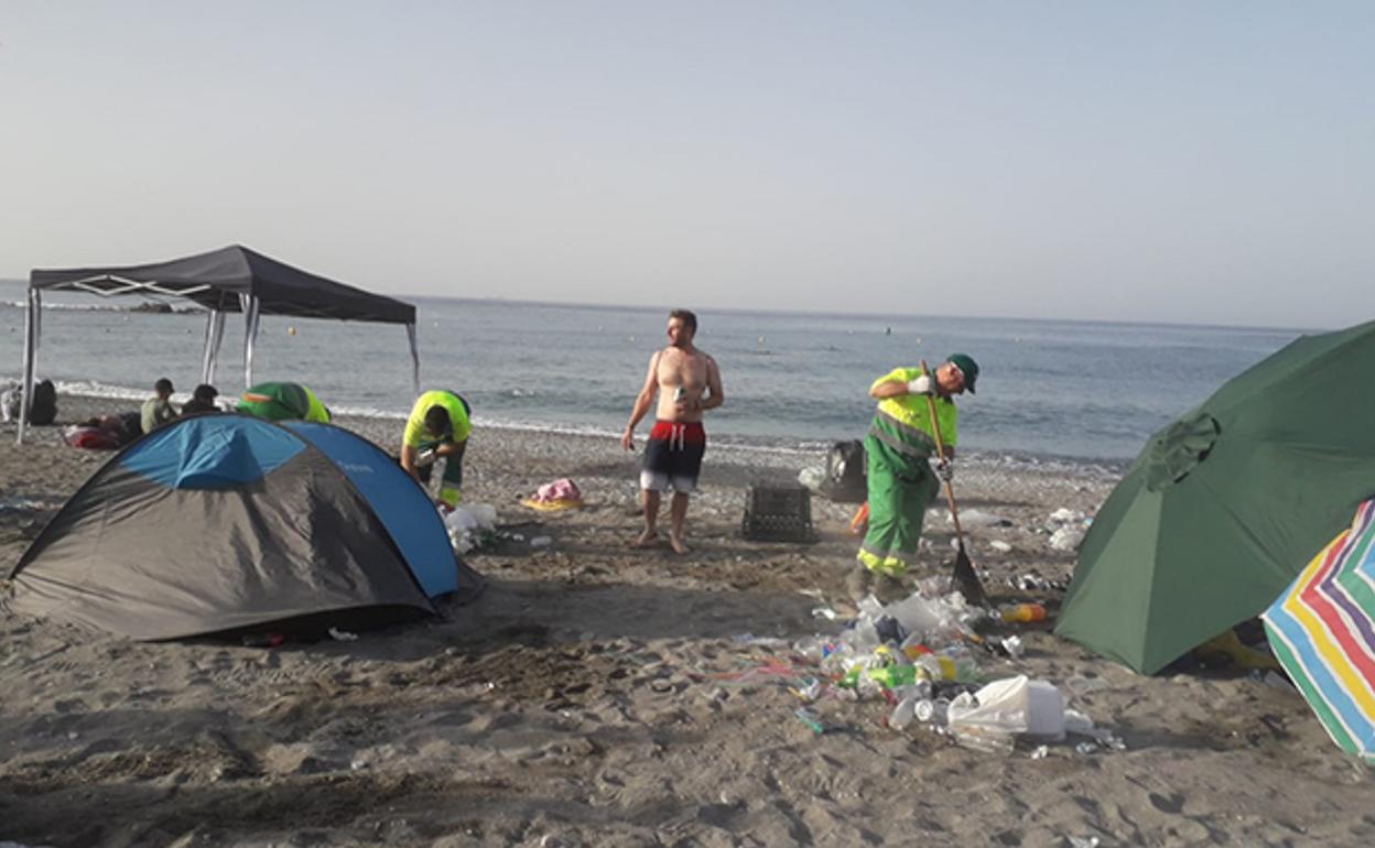 Operarios limpieza la playa tras la noche de San Juan del año pasado en Almuñécar.