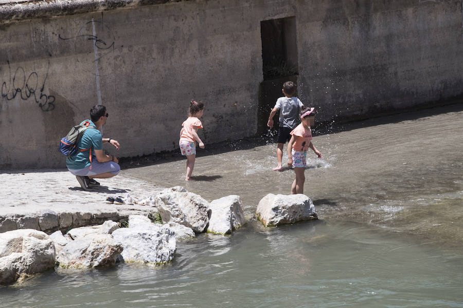 Granadinos y visitantes se las apañan en las calles para no sufrir mucho el enorme calor de estos días