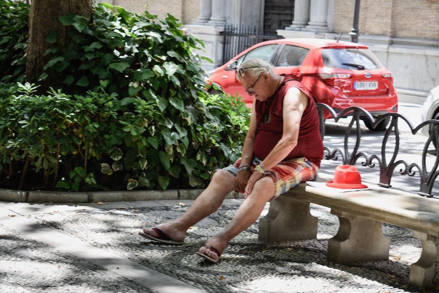 Granadinos y visitantes se las apañan en las calles para no sufrir mucho el enorme calor de estos días