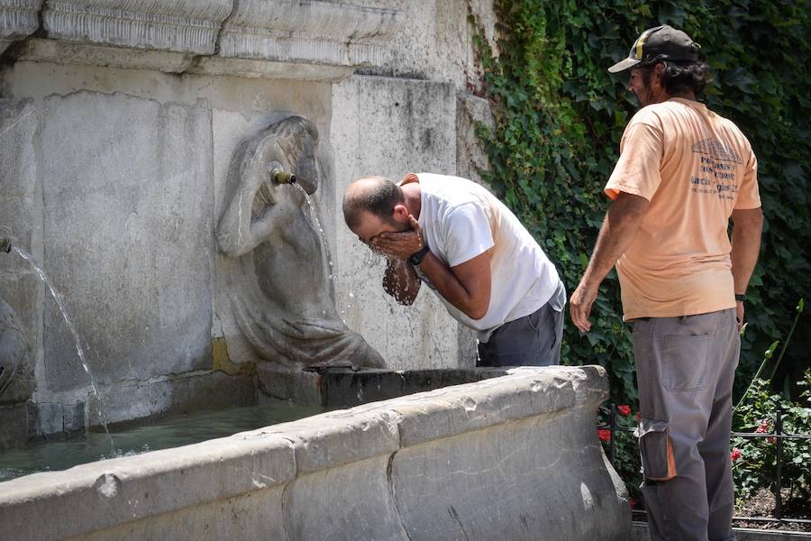 Granadinos y visitantes se las apañan en las calles para no sufrir mucho el enorme calor de estos días