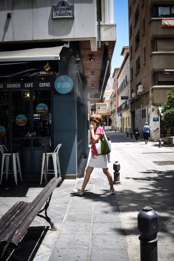 Granadinos y visitantes se las apañan en las calles para no sufrir mucho el enorme calor de estos días