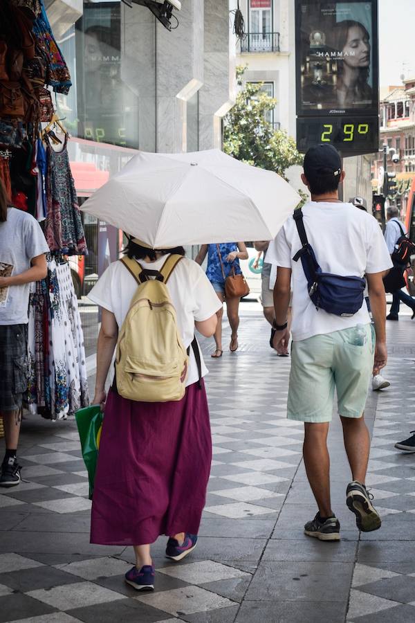Granadinos y visitantes se las apañan en las calles para no sufrir mucho el enorme calor de estos días