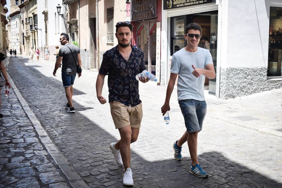 Granadinos y visitantes se las apañan en las calles para no sufrir mucho el enorme calor de estos días