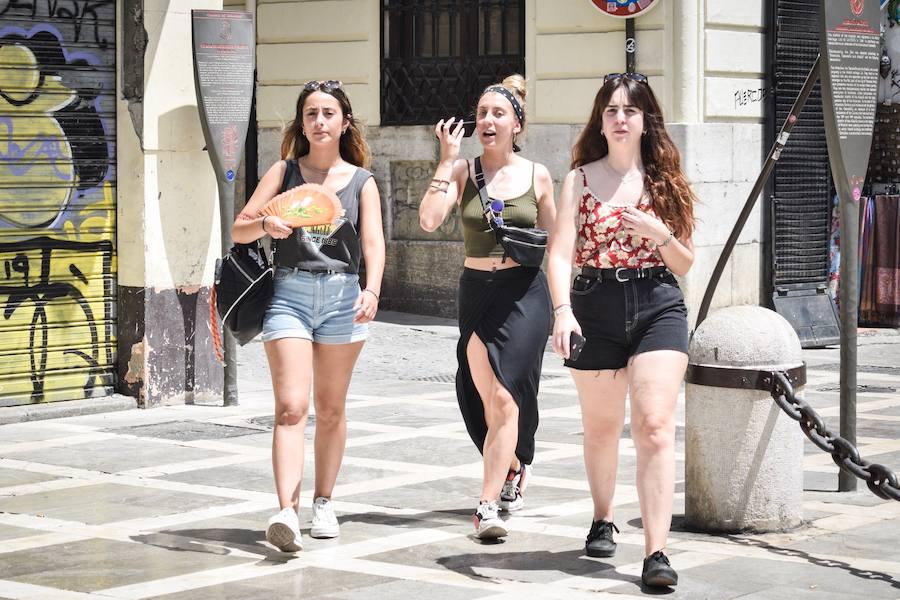 Granadinos y visitantes se las apañan en las calles para no sufrir mucho el enorme calor de estos días