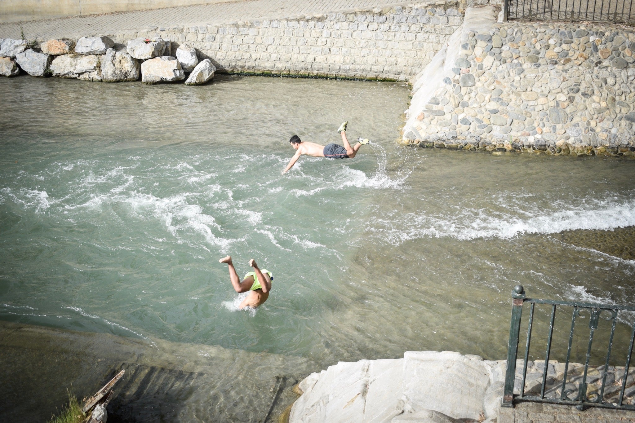 Granadinos y visitantes se las apañan en las calles para no sufrir mucho el enorme calor de estos días