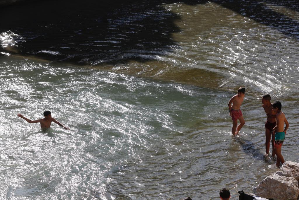 Granadinos y visitantes se las apañan en las calles para no sufrir mucho el enorme calor de estos días