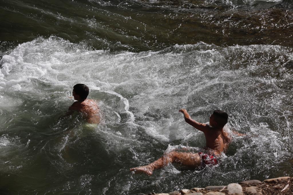 Granadinos y visitantes se las apañan en las calles para no sufrir mucho el enorme calor de estos días