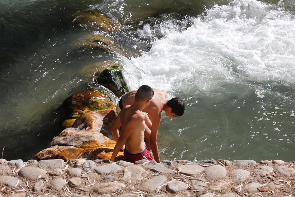 Granadinos y visitantes se las apañan en las calles para no sufrir mucho el enorme calor de estos días