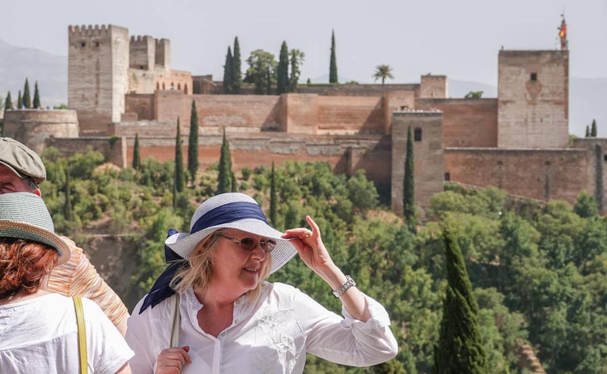 Una señora se protege del sol con un sombrero. 