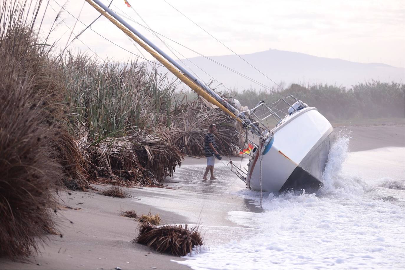 Fotos: Piden ayuda para sacar un velero de una playa de Salobreña