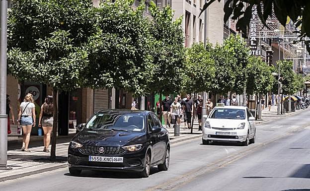Un Uber y un taxi circulan por la calle Recogidas, de acceso libre para los VTC desde el auto de medidas cautelares.