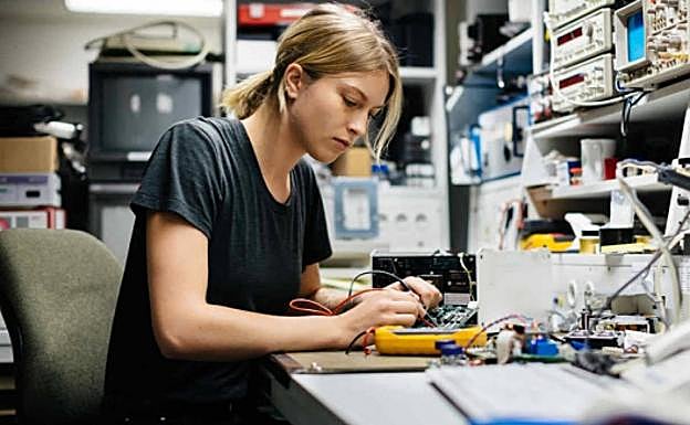 Una joven ingeniera trabaja en un laboratorio de robótica. 