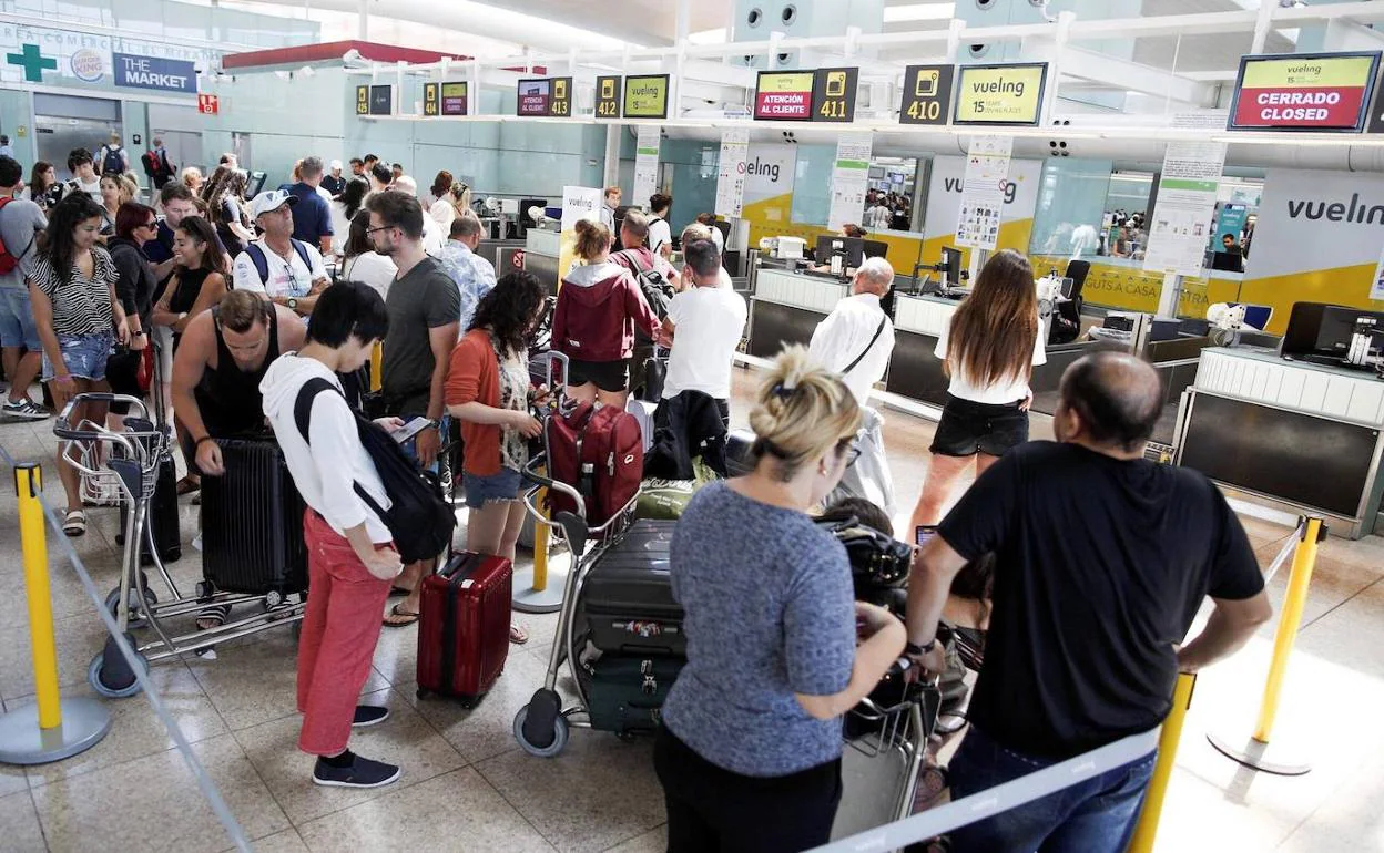 Pasajeros haciendo cola en el aeropuerto del Prat, en Barcelona.