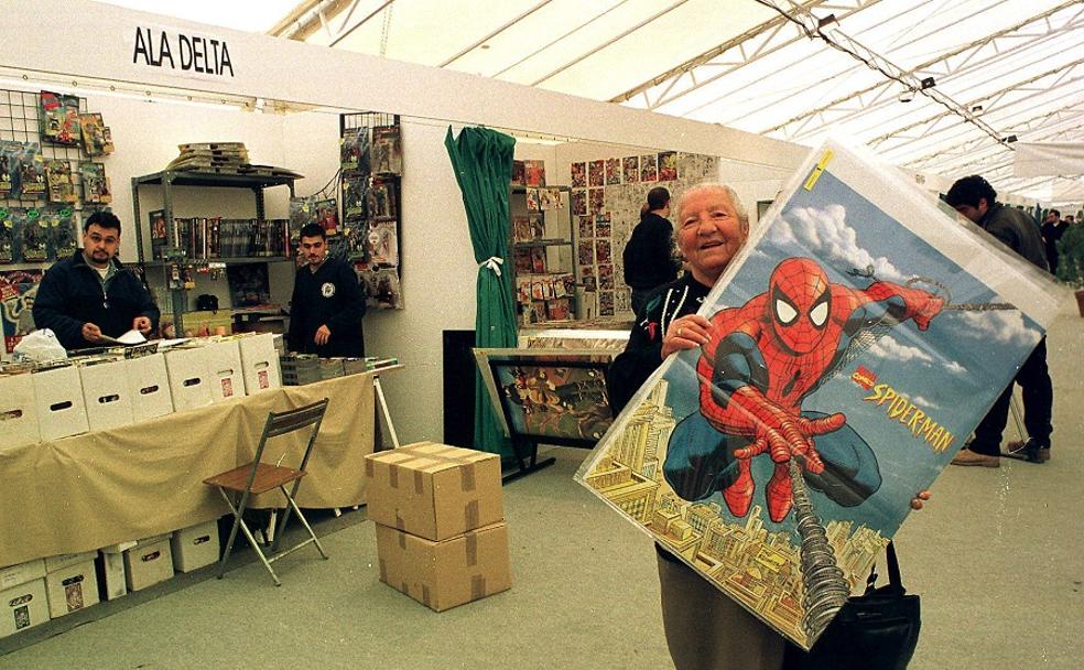 Una mujer sostiene un póster con la portada de un cómic de Spiderman en la carpa del Salón Internacional del Cómic de Granada del año 2001.