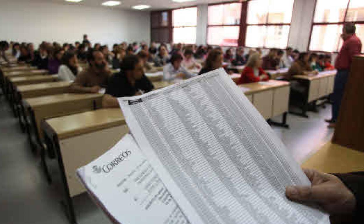 Un grupo de personas, examinándose a las oposiciones de Correos.