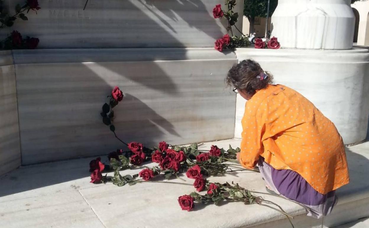Una defensora del Monumento a Los Coloraos coloca, esta mañana, flores en su base. 