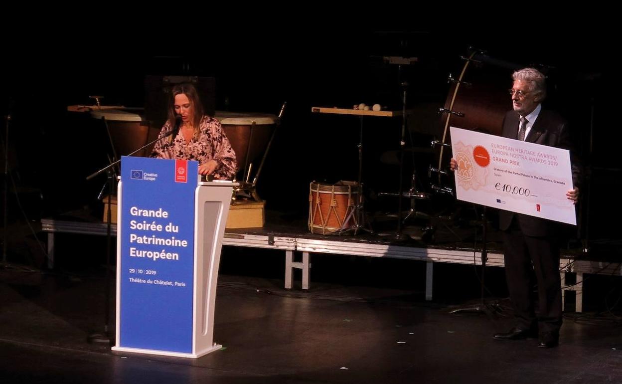 El presidente de la Fundación Europa Nostra, el tenor español Plácido Domingo (d), entrega un cheque de 10.000 euros a Rocío Díaz. 