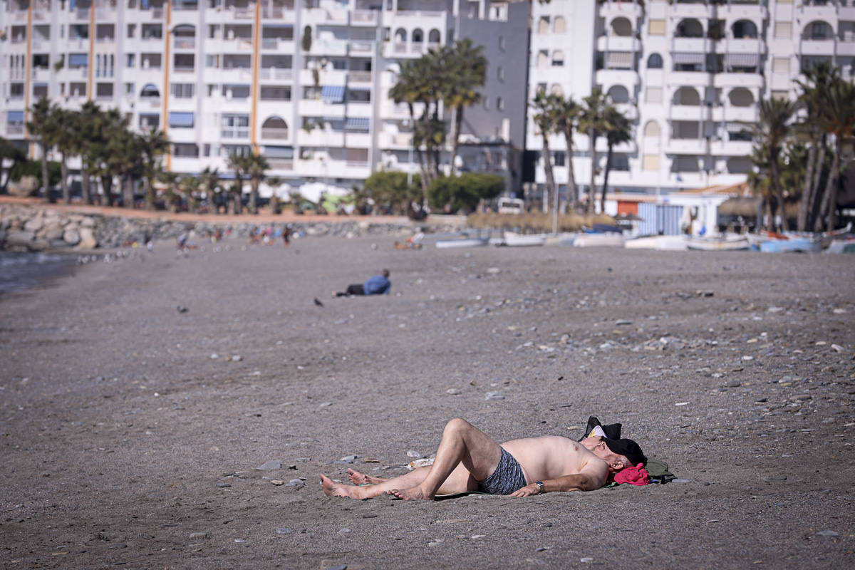 Decenas de turistas ya se encuentran en las playas del litoral granadino, que registrará una temperatura primaveral este fin de semana 