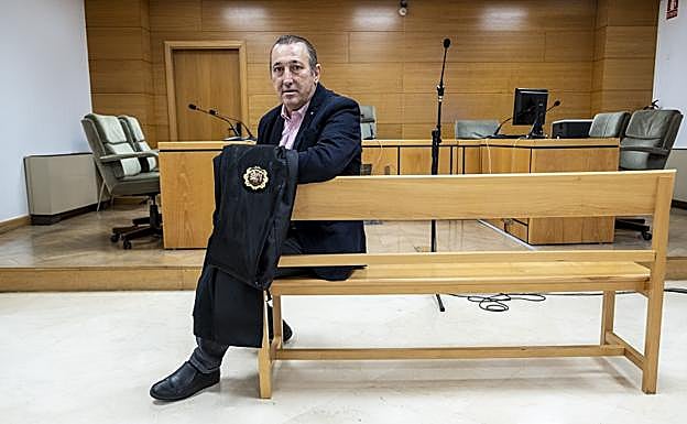 El juzgador, sentado en el banquillo de los acusados de su sala de vistas