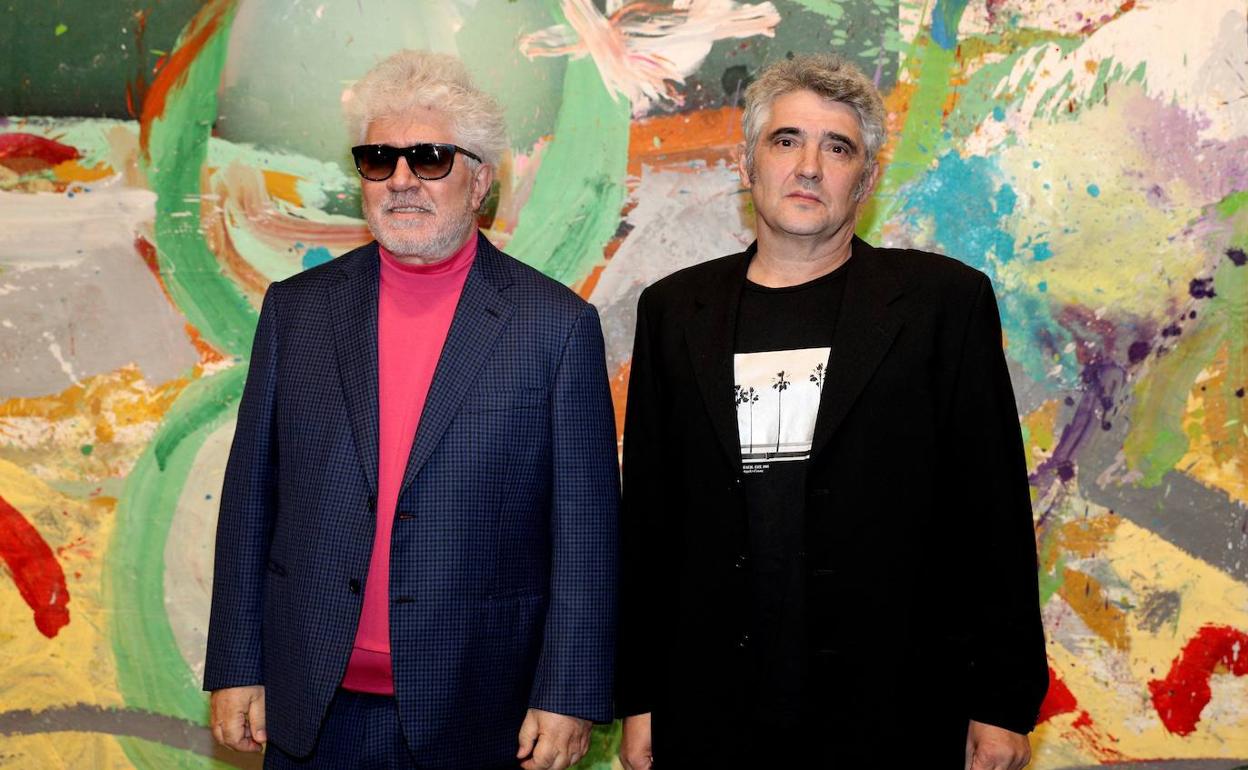 Padro Almodóvar y Jorge Galindo ante uno de los grandes lienzos de la su exposición 'Flores' 