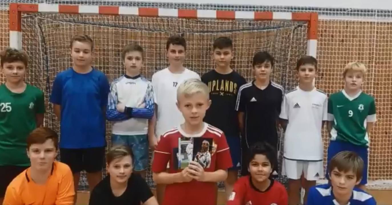 El pequeño Jan, acompañado por sus amigos, enseña las fotos frimadas. 