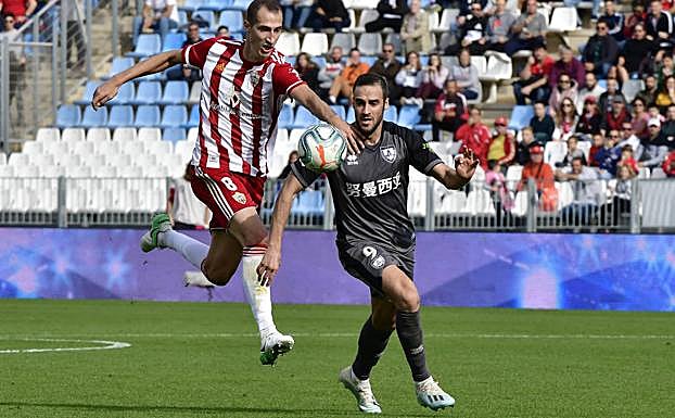 Petrovic intenta que Higinio no llegue al balón. 