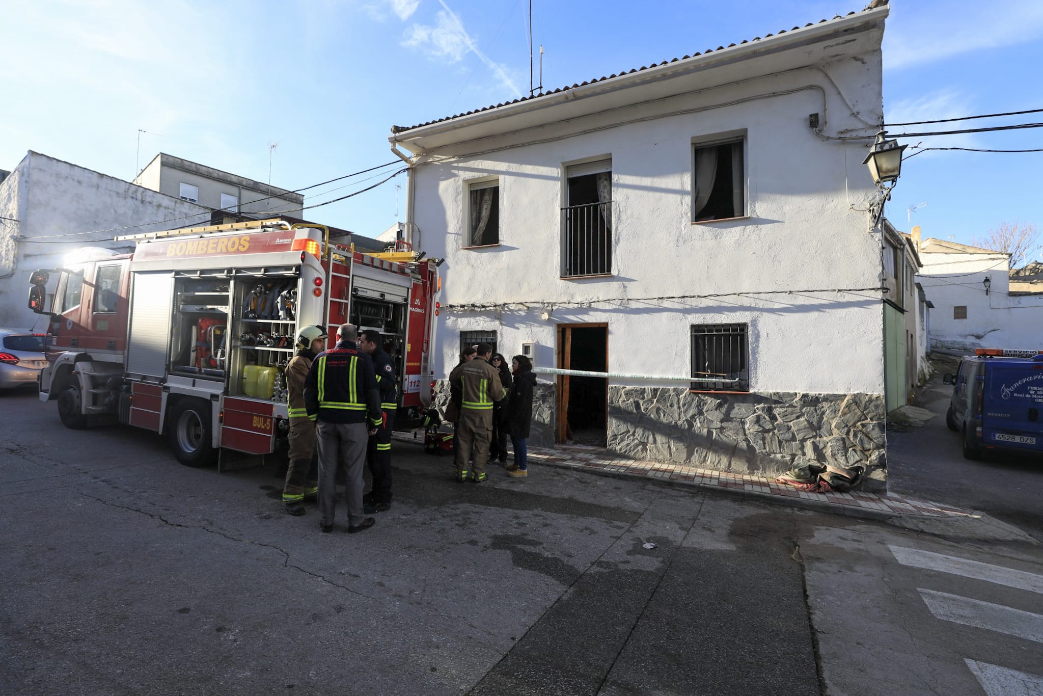 Miembros de la funeraria proceden a guardar uno de los féretros en el vehículo.