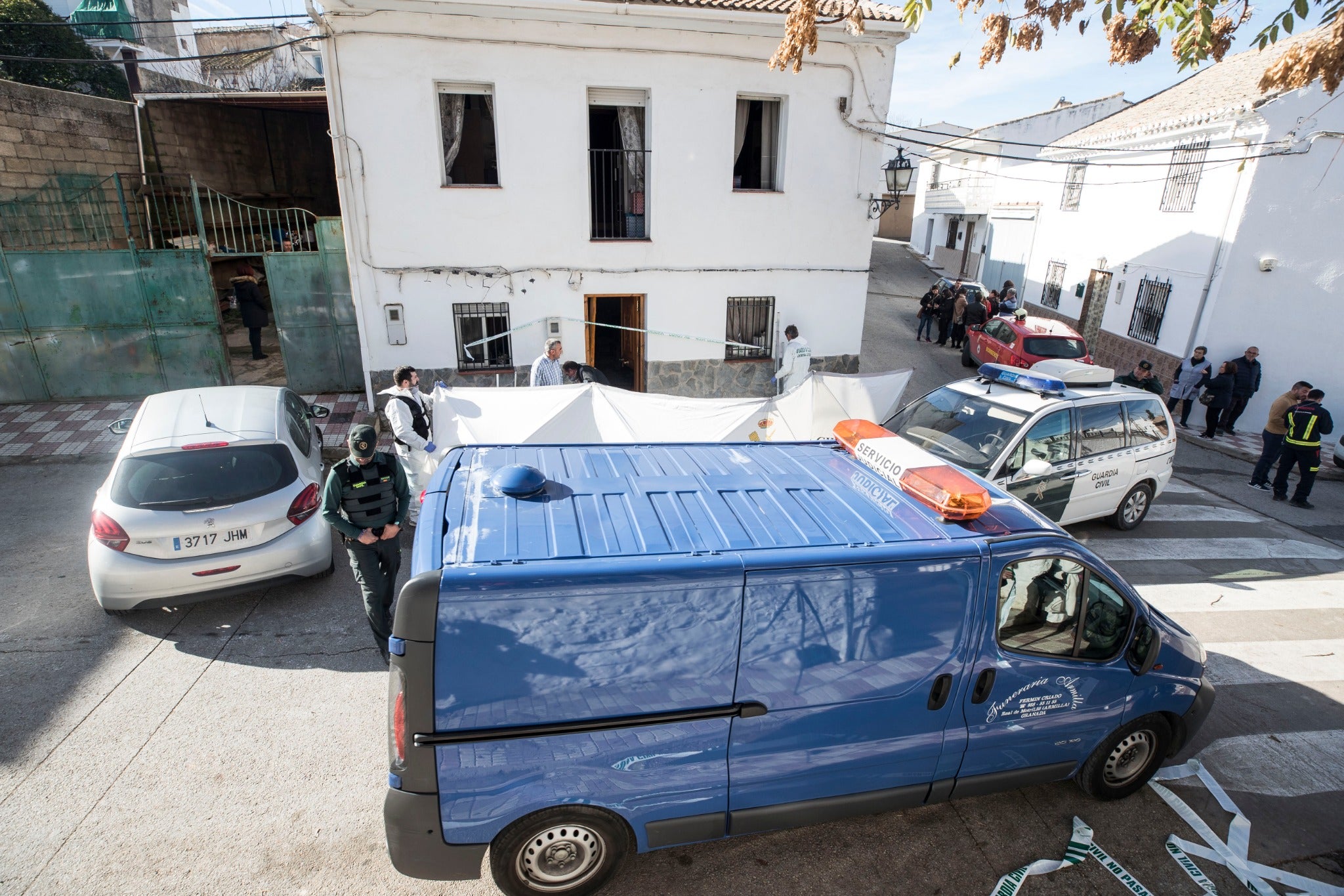 Miembros de la funeraria proceden a guardar uno de los féretros en el vehículo.